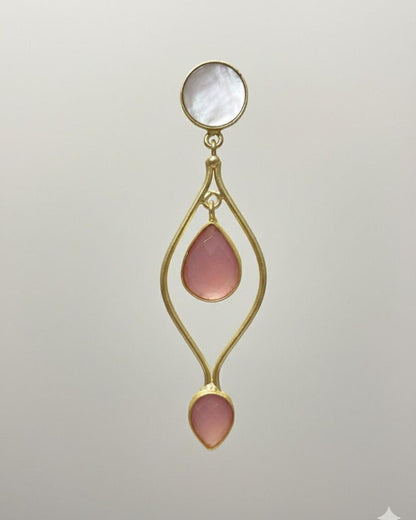 Gold earring with pink teardrop stones on a light gray background