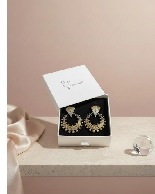 Gold hoop earrings in a white box on a light pink background