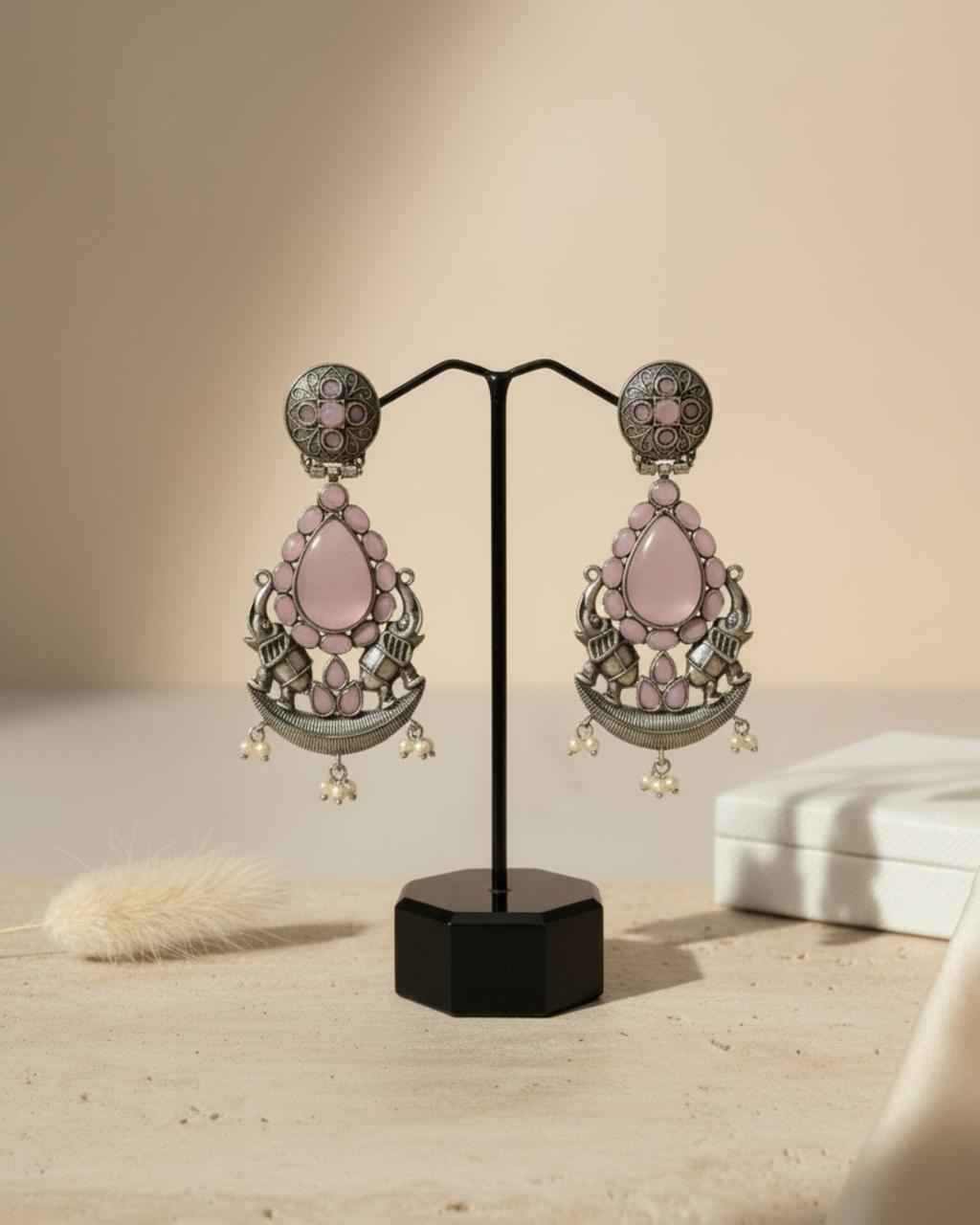 Silver‑tone Chicshukra earrings with pink rose quartz teardrop and pearl jhumka accents on a black display stand.