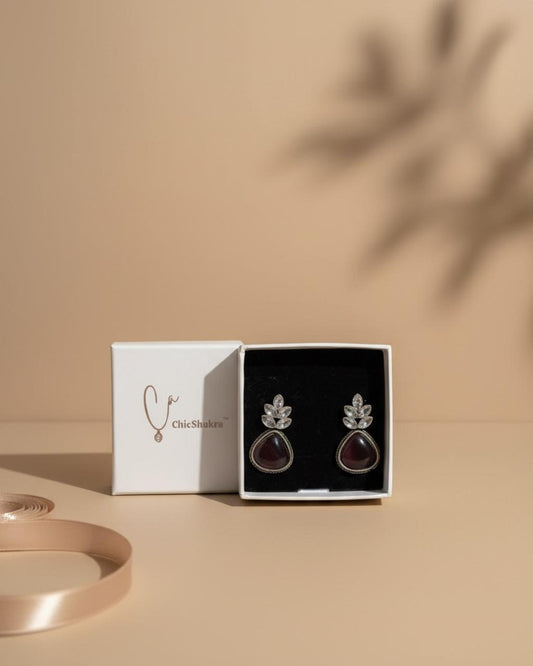 Jewelry box with a pair of earrings on a beige background