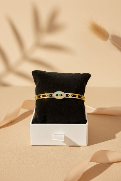 Gold bracelet with a black cushion on a beige background