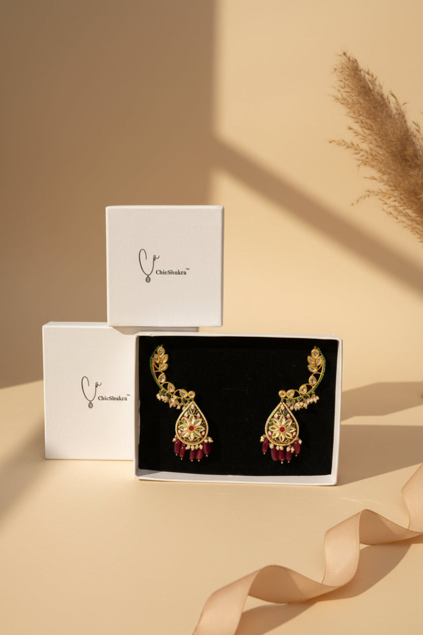 Decorative earrings in a box with ChikShukra branding on a checkered background