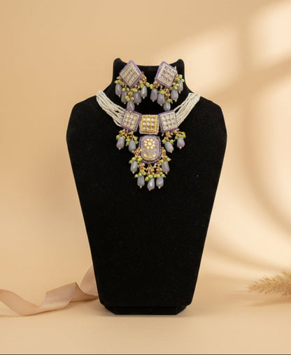 ChicShukra imitation jewellery necklace set with lavender enamel kundan pendant, pearl beads, green accents, and matching earrings on a mannequin.