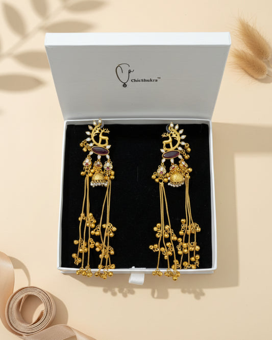 Gold earrings with intricate designs in a white box with 'chicShukra' branding.