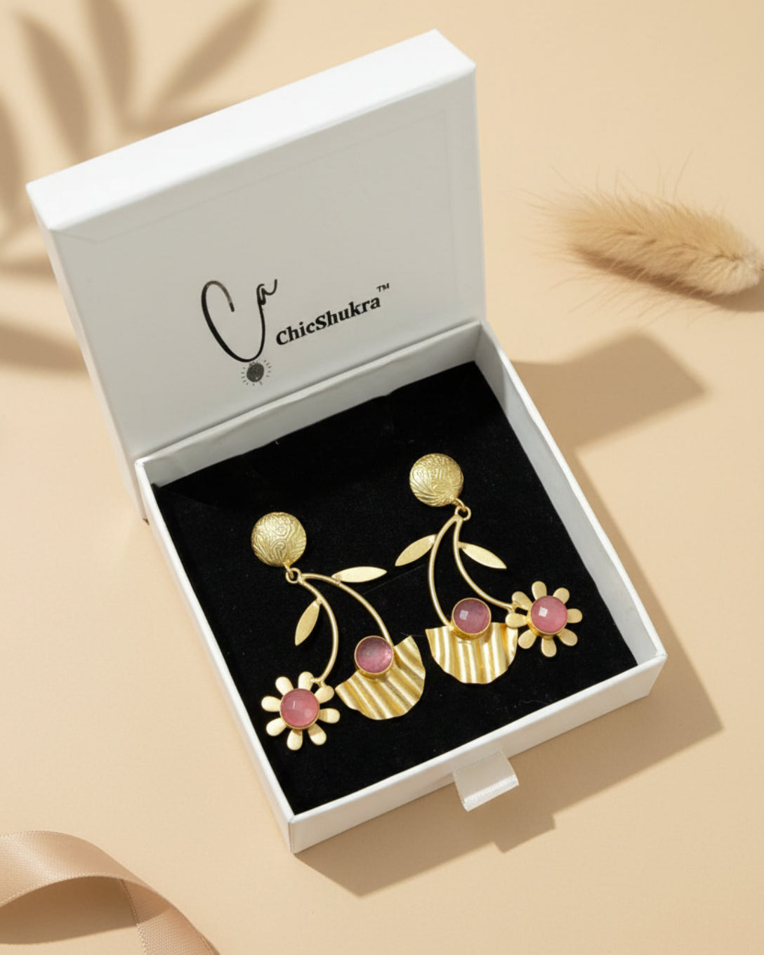 Gold and pink earrings in a ChicShukra box