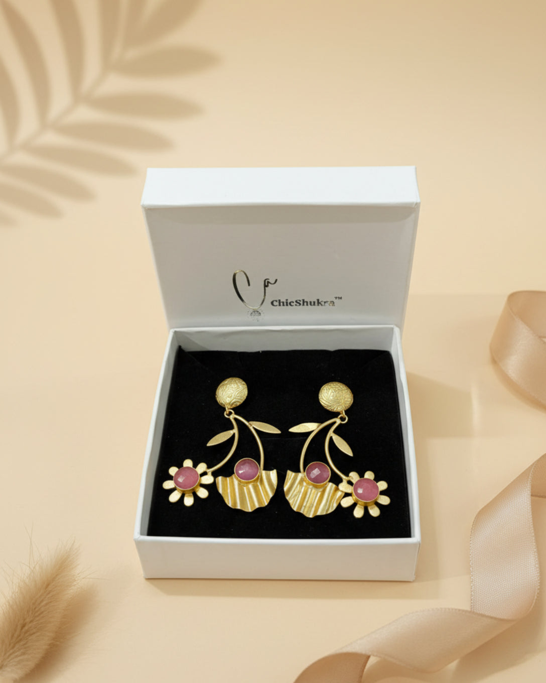 Gold earrings with pink stones in a ChicShubh box