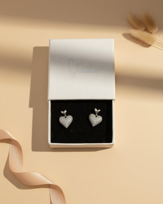 ChicShukra anti-tarnish silver heart-shaped stud earrings featuring a dangling pave heart encrusted with shimmering cubic zirconia stones.