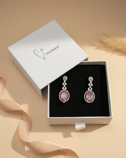 ChicShukra anti-tarnish rhodium-plated drop earrings featuring a large oval pink stone centerpiece and shimmering American Diamond (AD) micro-pave accents.