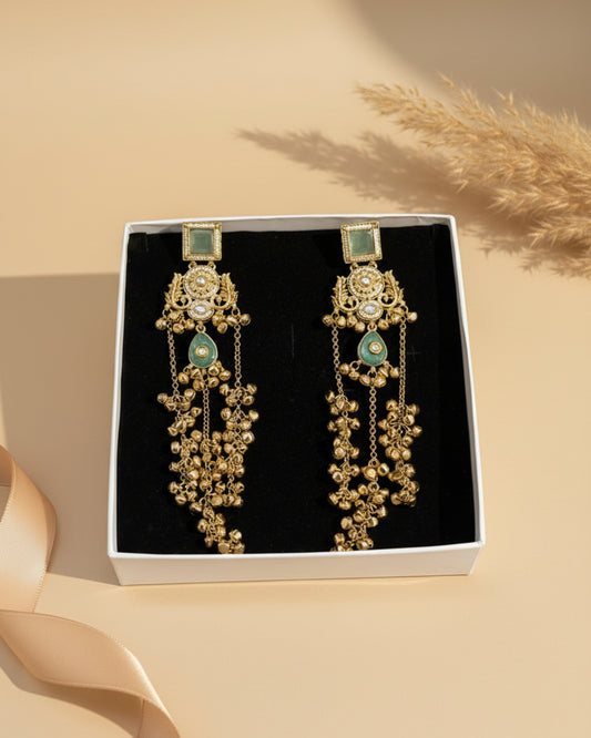 Gold and green earrings in a box with 'ChicShukra' branding.
