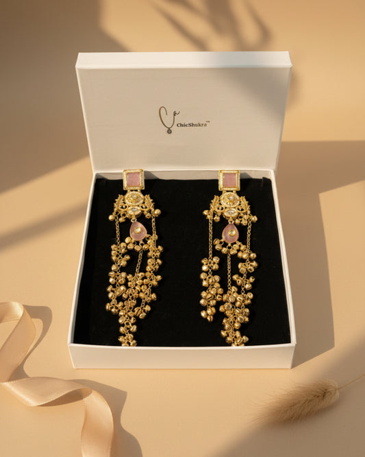 Gold earrings with pink stones in a 'ChicShukra' box.